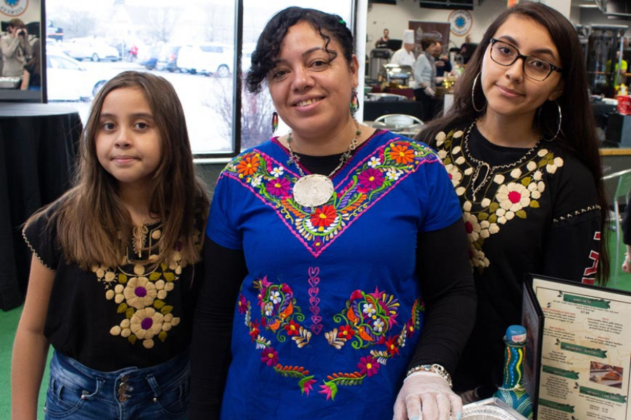 A woman and two girls are posing for a picture in a restaurant.