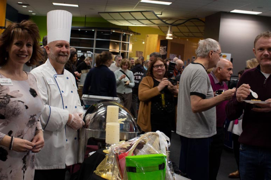 A chef is standing in front of a crowd of people.