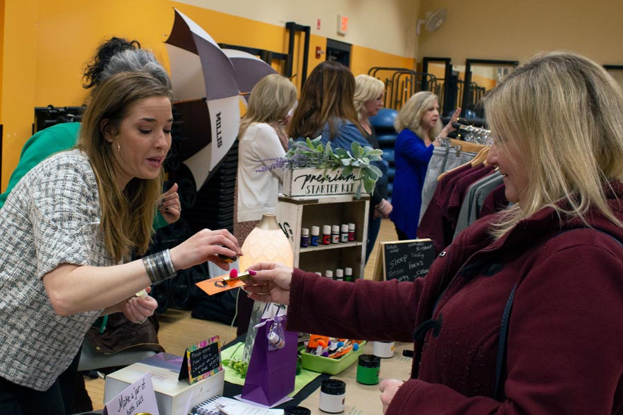 A woman is giving a gift to another woman in a store.