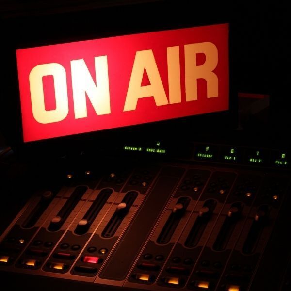 A red sign that says on air above a mixer