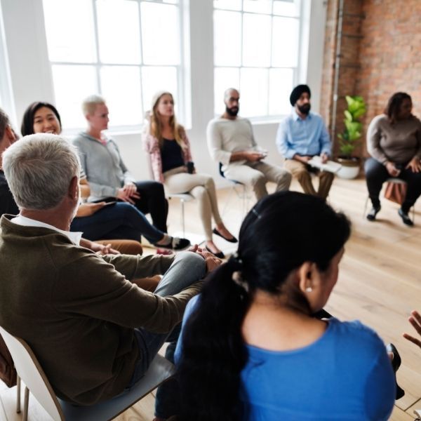 A group of people are sitting in a circle in a room.