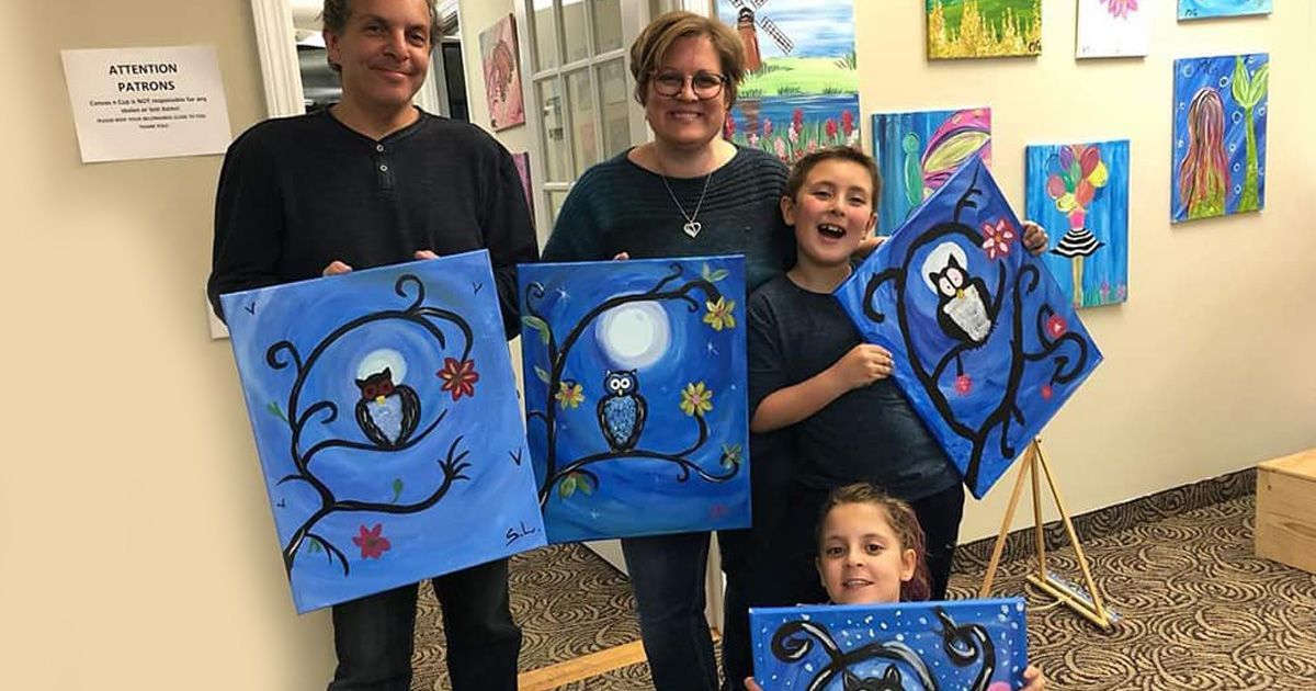 family holding art canvases