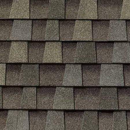 A close-up, top-down view of overlapping dark brown and gray asphalt roofing shingles arranged in a repeating pattern.