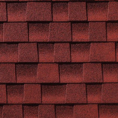 A close up of a row of red shingles on a roof.