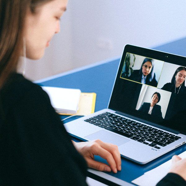 A woman is sitting at a desk using a laptop computer