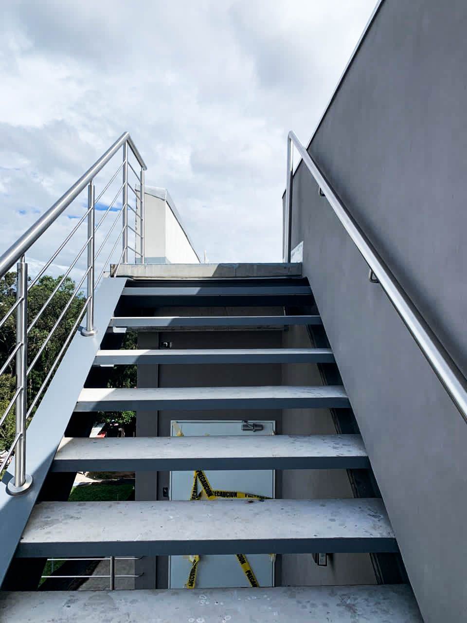 Un conjunto de escaleras que conducen a un edificio con barandilla de acero inoxidable.