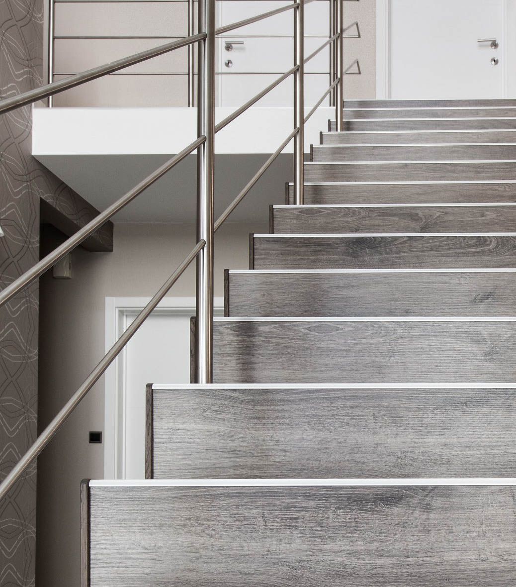 Un conjunto de escaleras de madera con barandilla de metal.