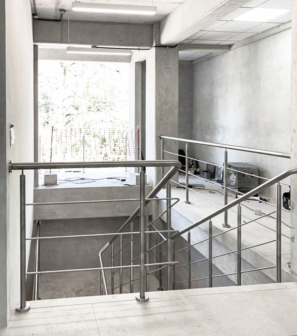 Una fotografía en blanco y negro de una escalera con barandilla de metal.