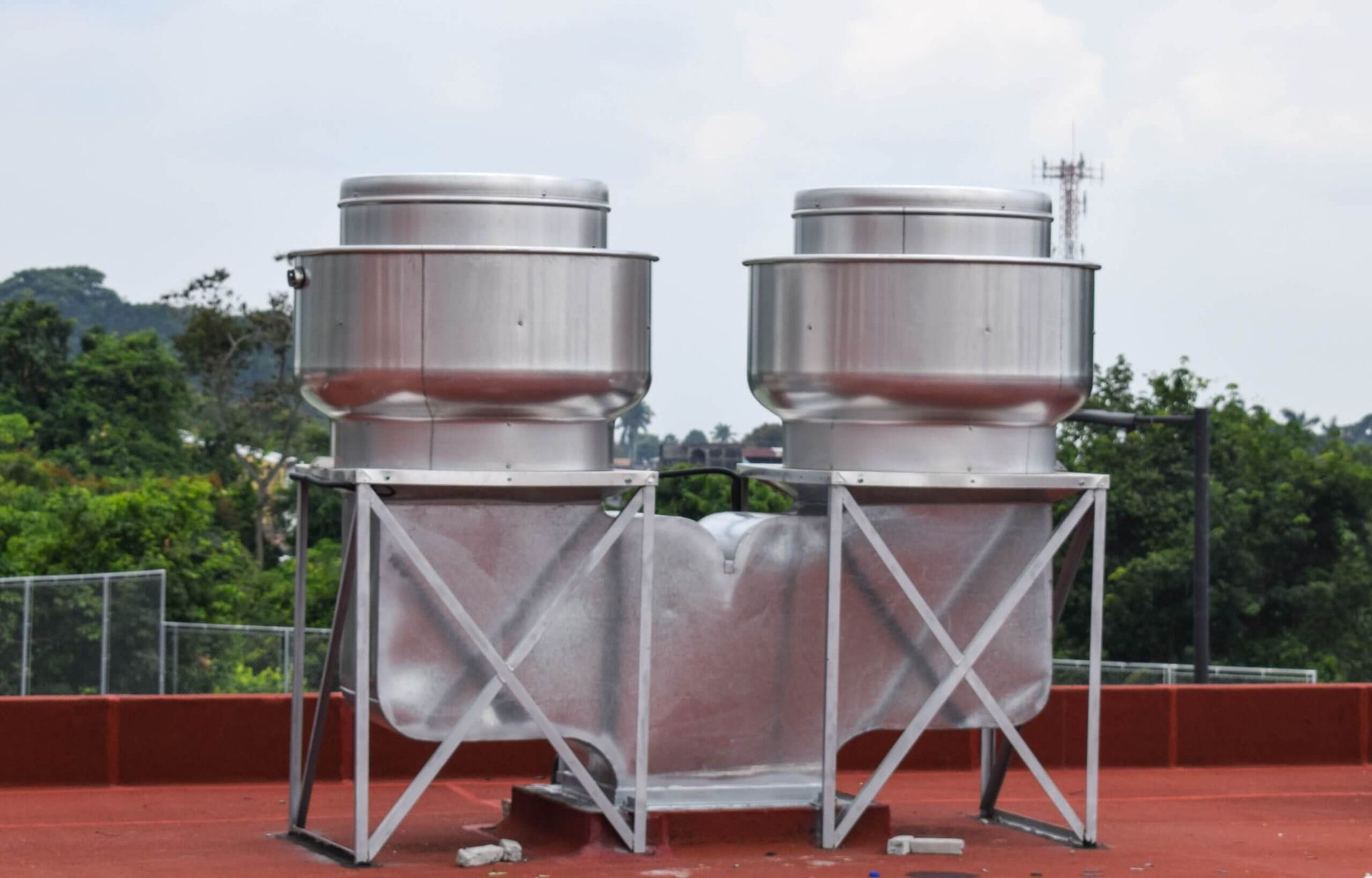 Dos extractores de acero inoxidable están colocados encima de un techo.