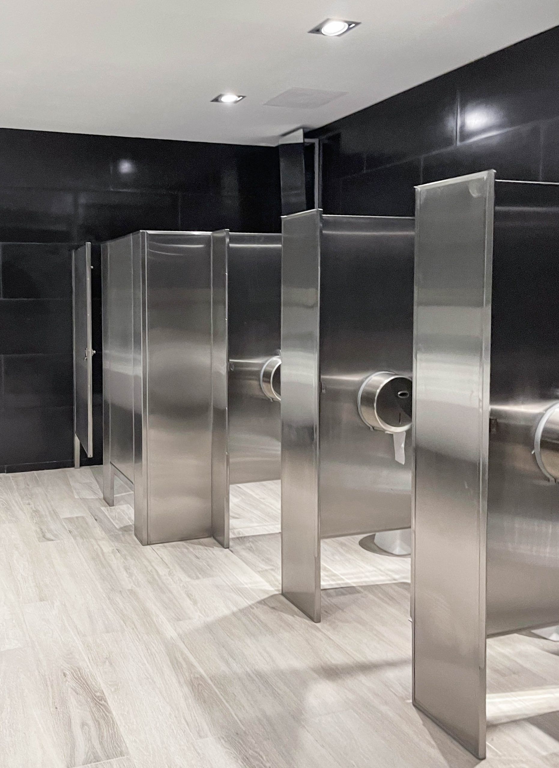 Una fila de puestos de acero inoxidable en un baño público.