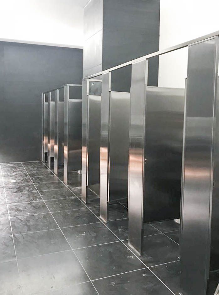 Una fila de puestos de acero inoxidable en un baño público.