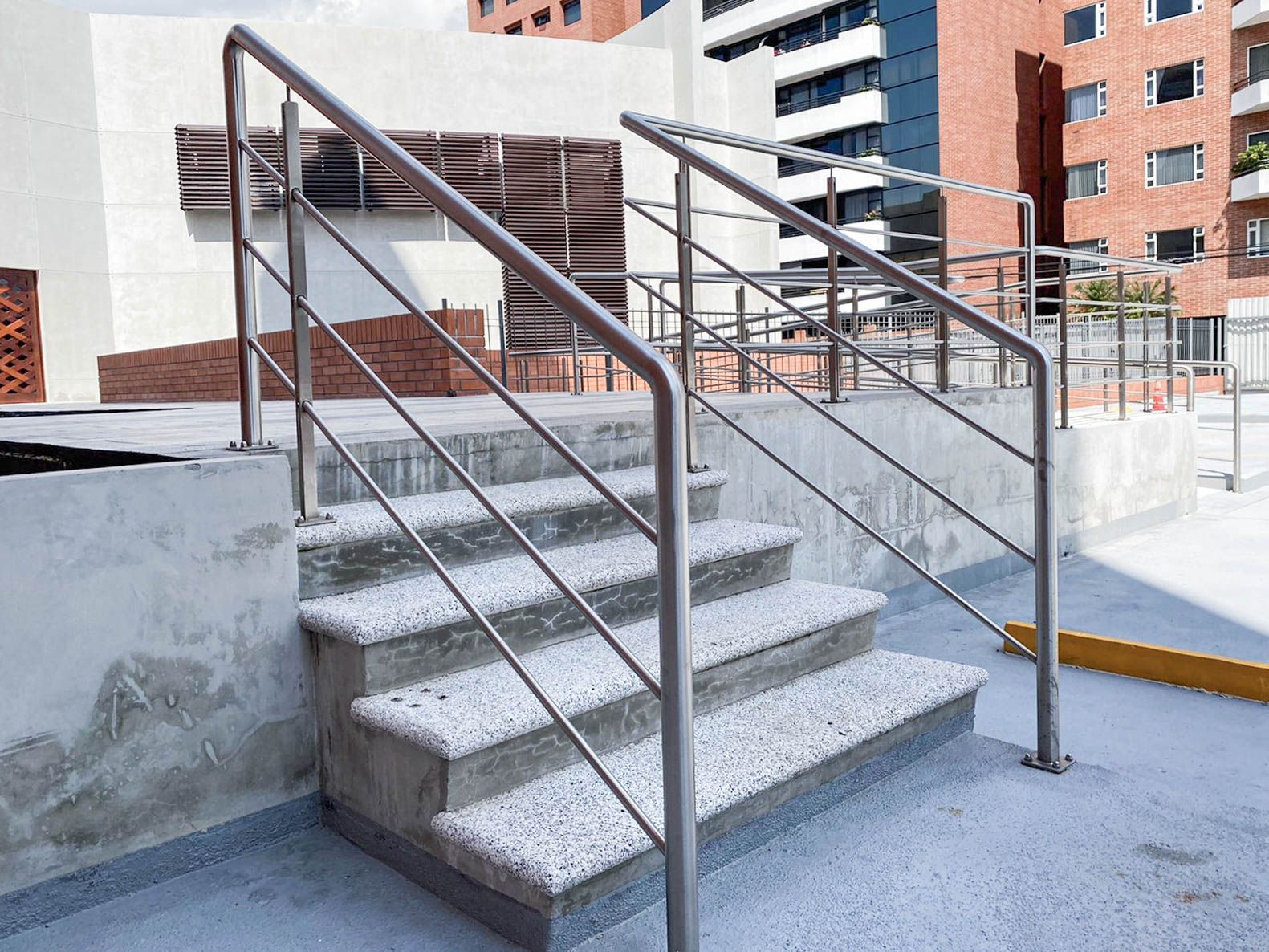 Un conjunto de escaleras con barandilla de acero inoxidable que conducen a un edificio.