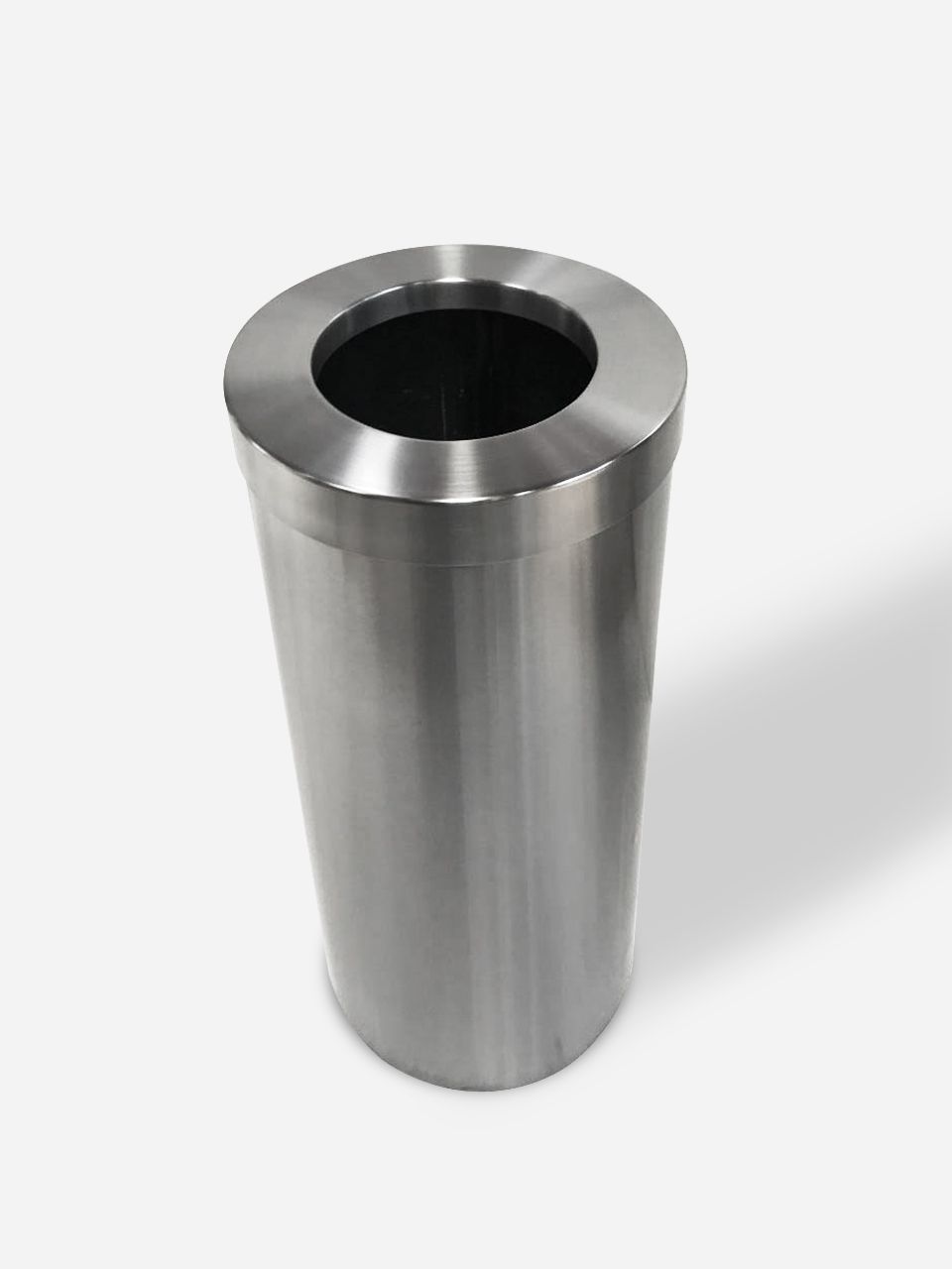 Un bote de basura de acero inoxidable está sobre una superficie blanca.