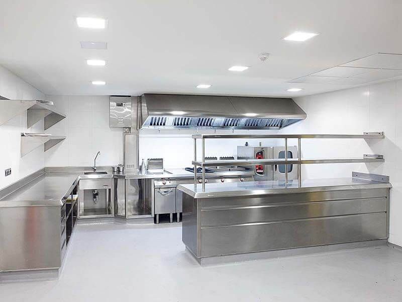 Una amplia cocina con electrodomésticos de acero inoxidable y encimeras.