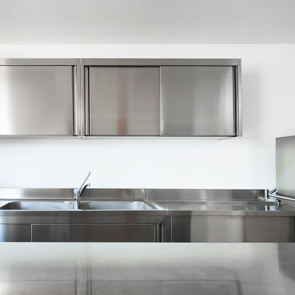 Una cocina con gabinetes de acero inoxidable y fregadero