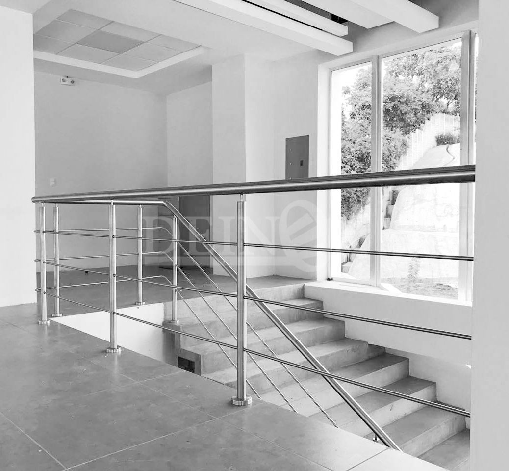 Una fotografía en blanco y negro de una escalera con barandilla de acero inoxidable.