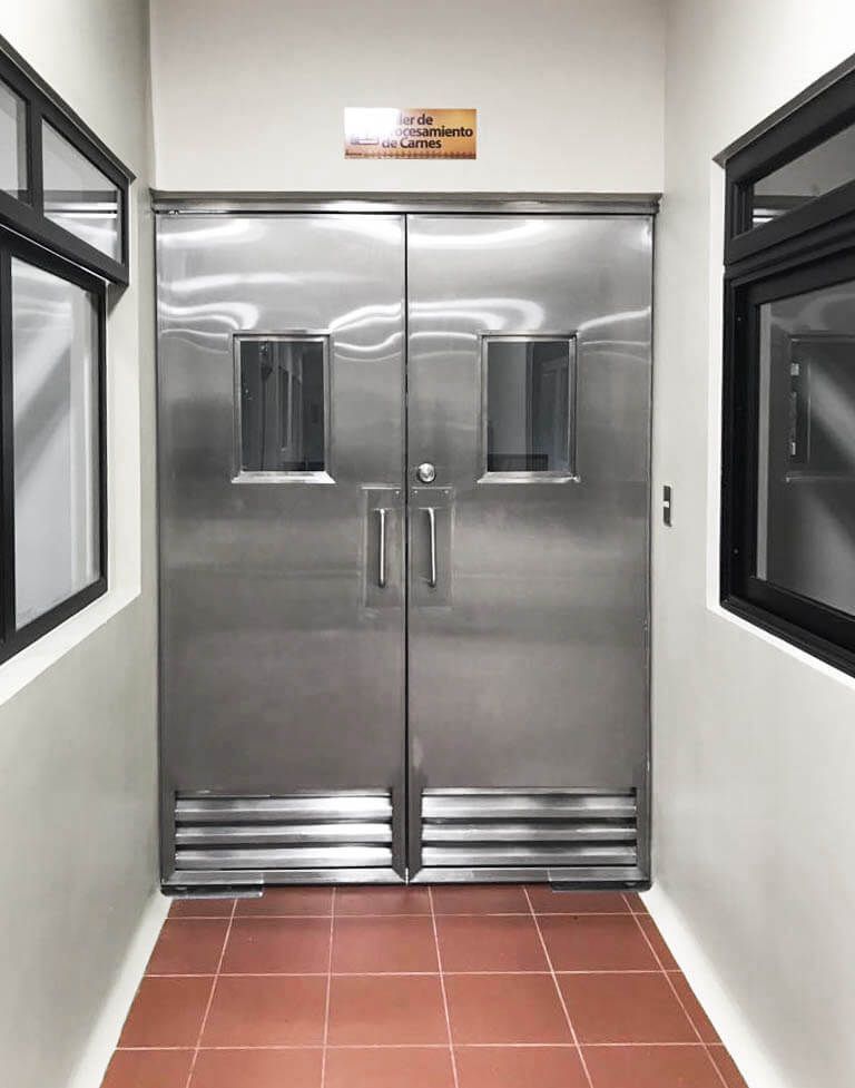 Un pasillo con puertas y ventanas de acero inoxidable.