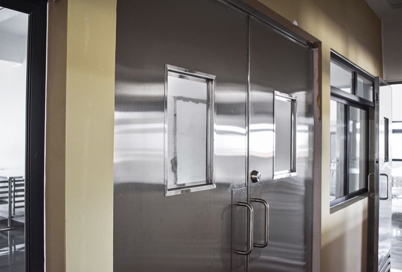 Un pasillo con puertas y ventanas de acero inoxidable.