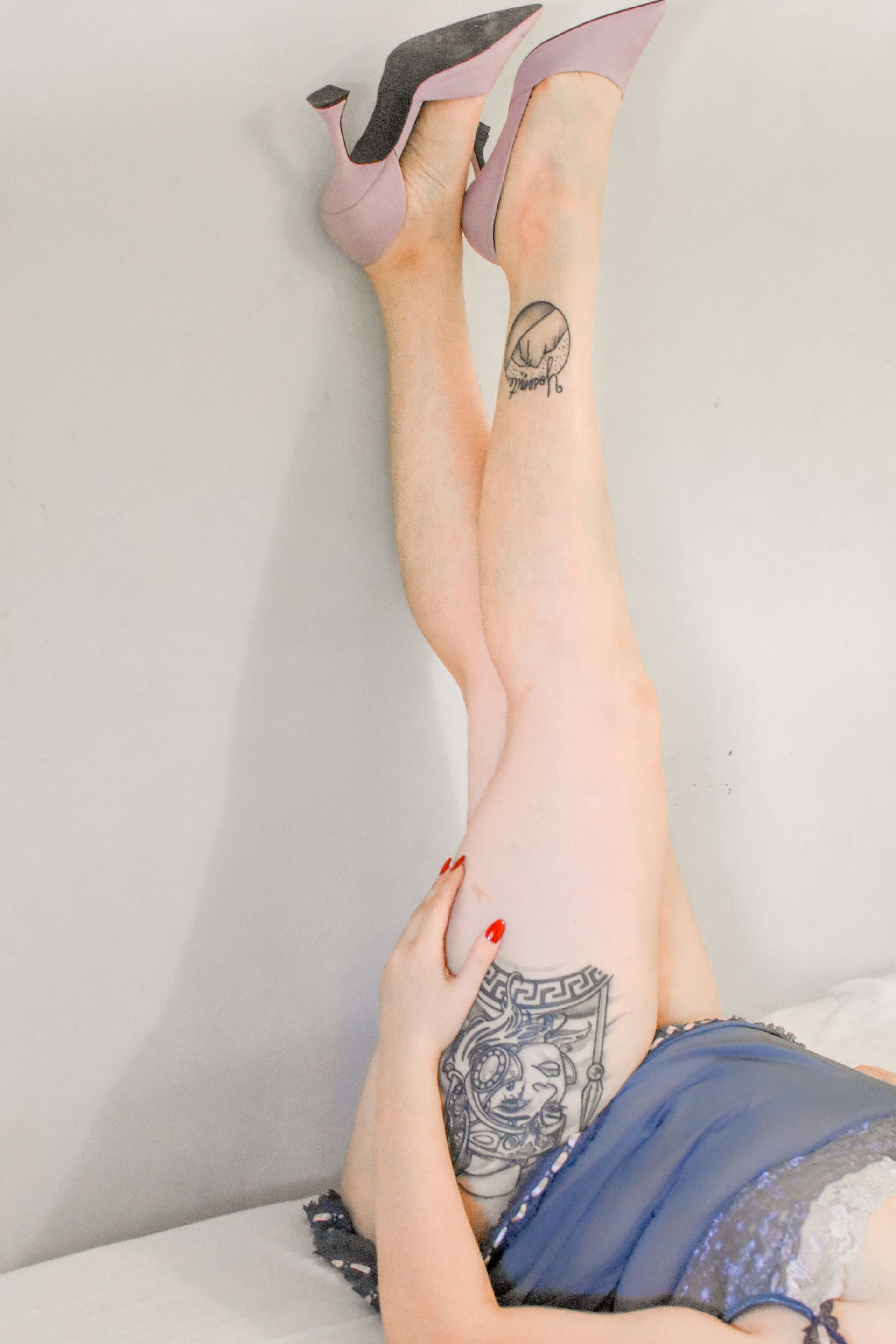 A woman is laying on her back with her legs up in the air.