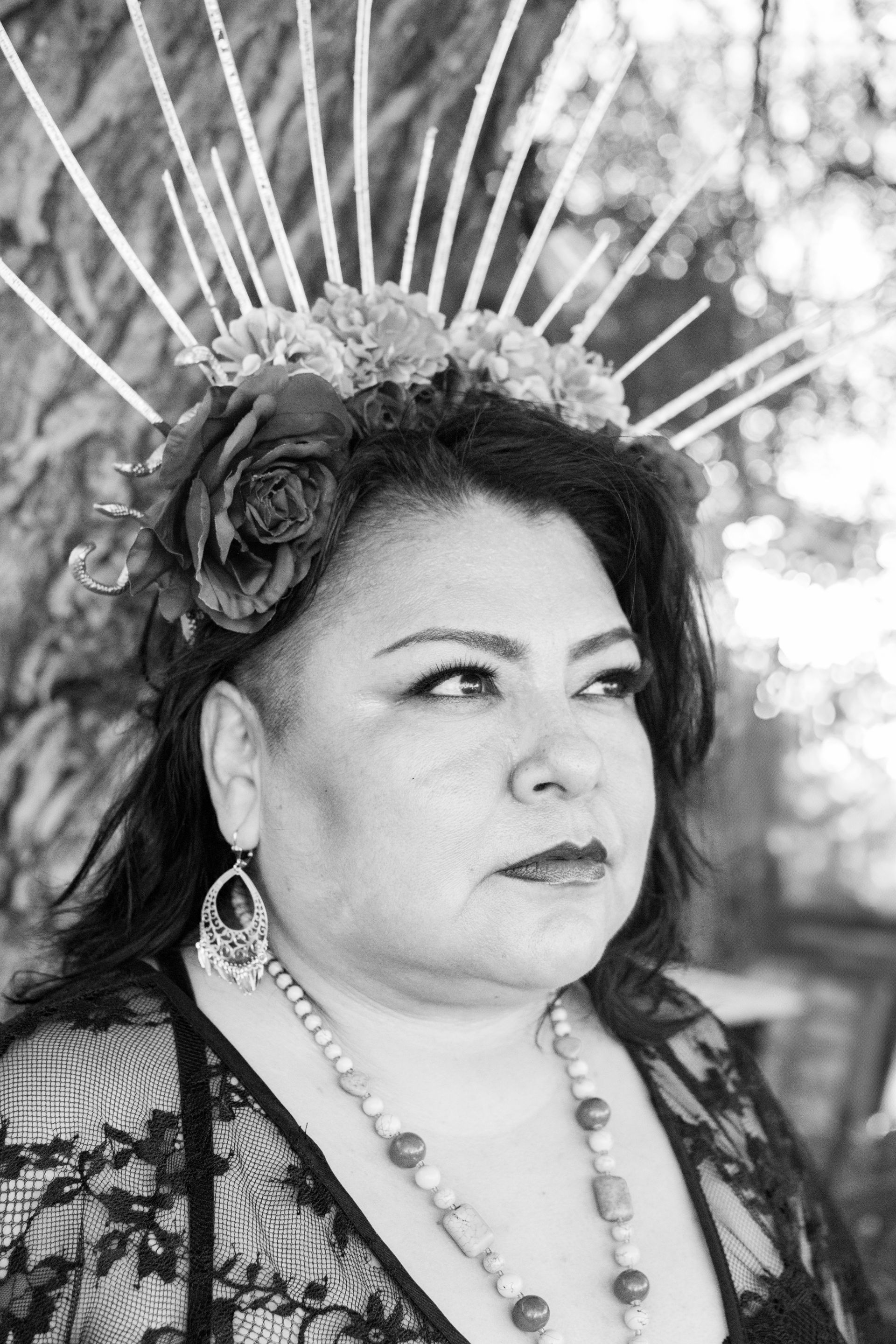 A black and white photo of a woman wearing a crown and earrings. Over 40 boudoir. 
