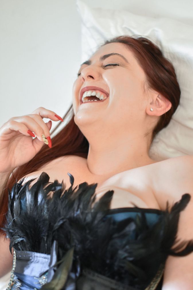 A woman in a corset is laughing. Boudoir. 