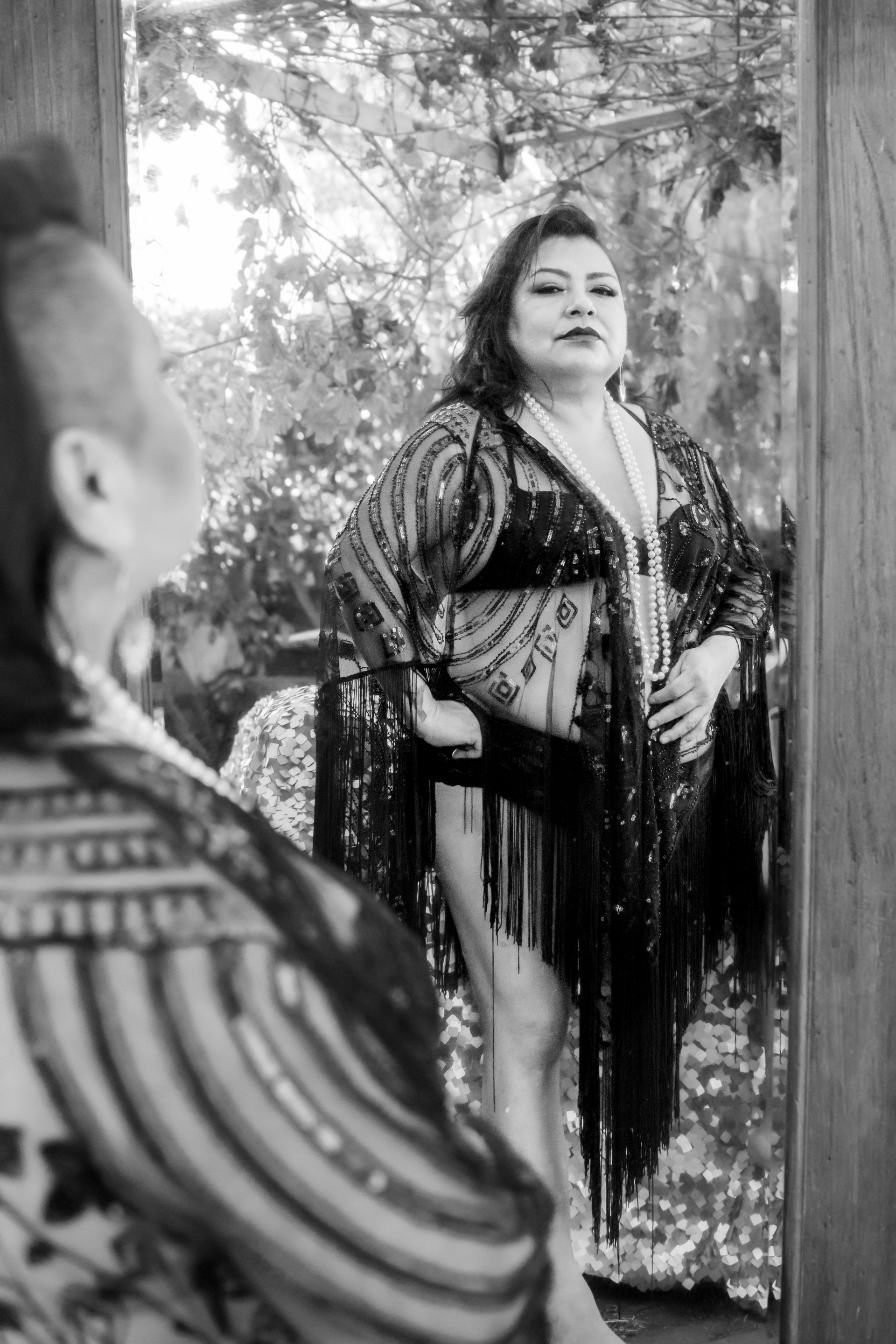 A woman is standing in front of a mirror looking at her reflection. Female Empowerment. 