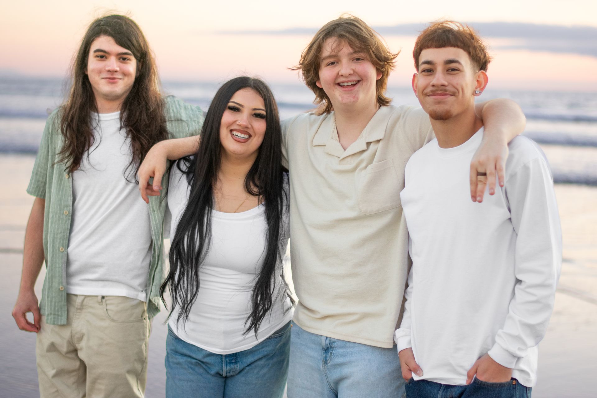 A group of young people are posing for a picture on the beach. Seniors. Grads. Graduates. 