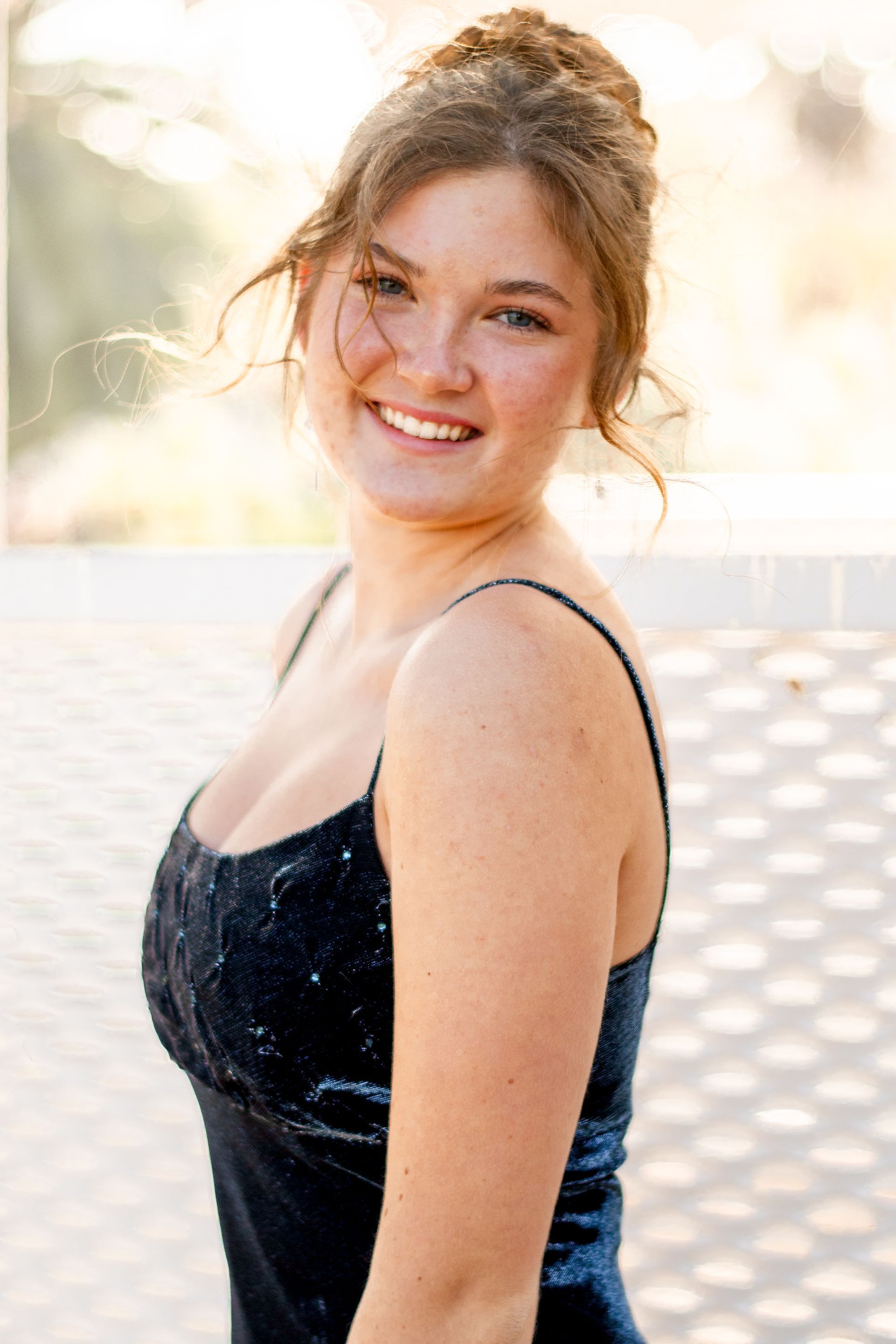 A woman in a black dress is smiling for the camera in near Rolling Hills