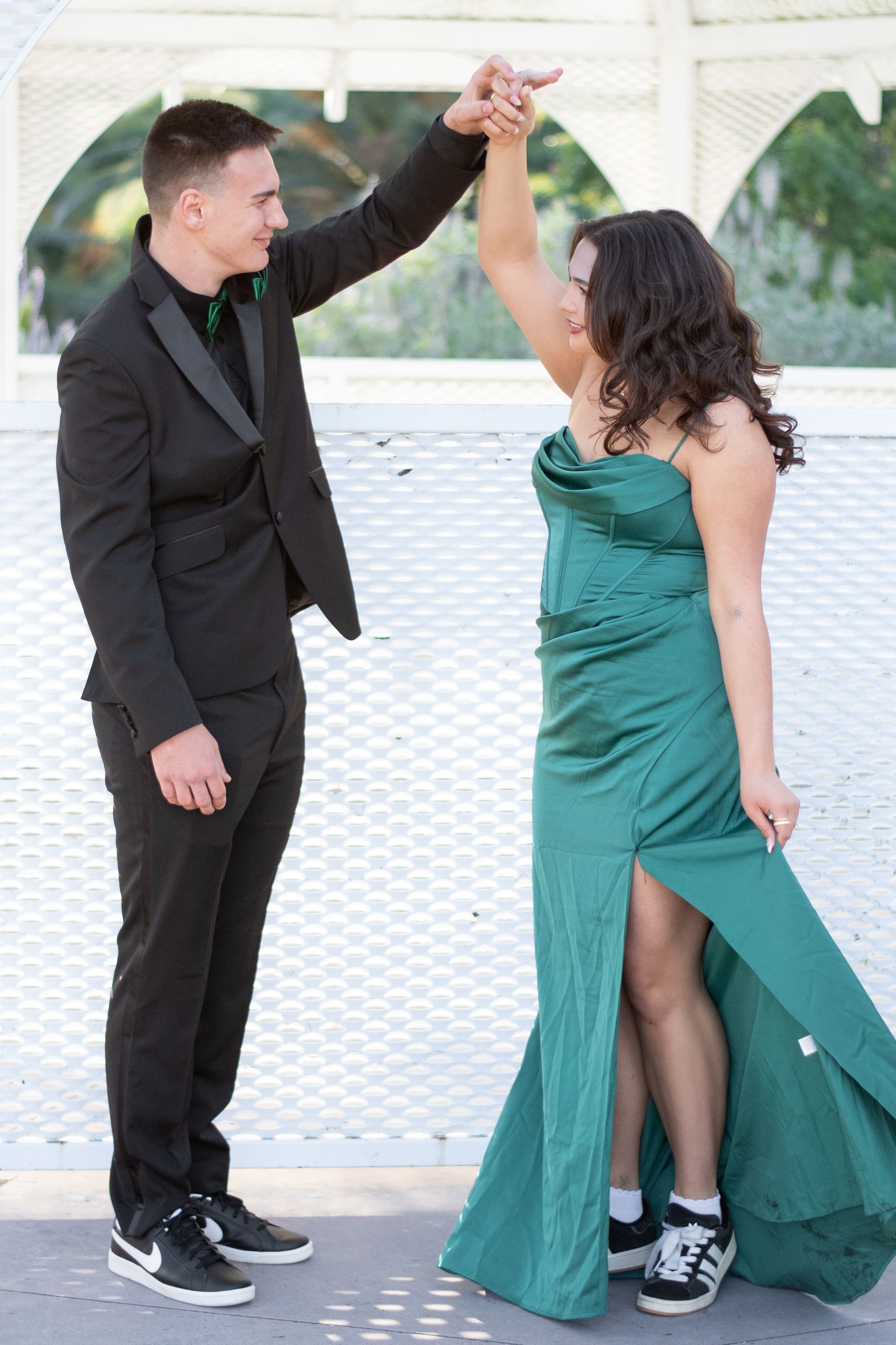 A man in a tuxedo is dancing with a woman in a green dress in Southern California.
