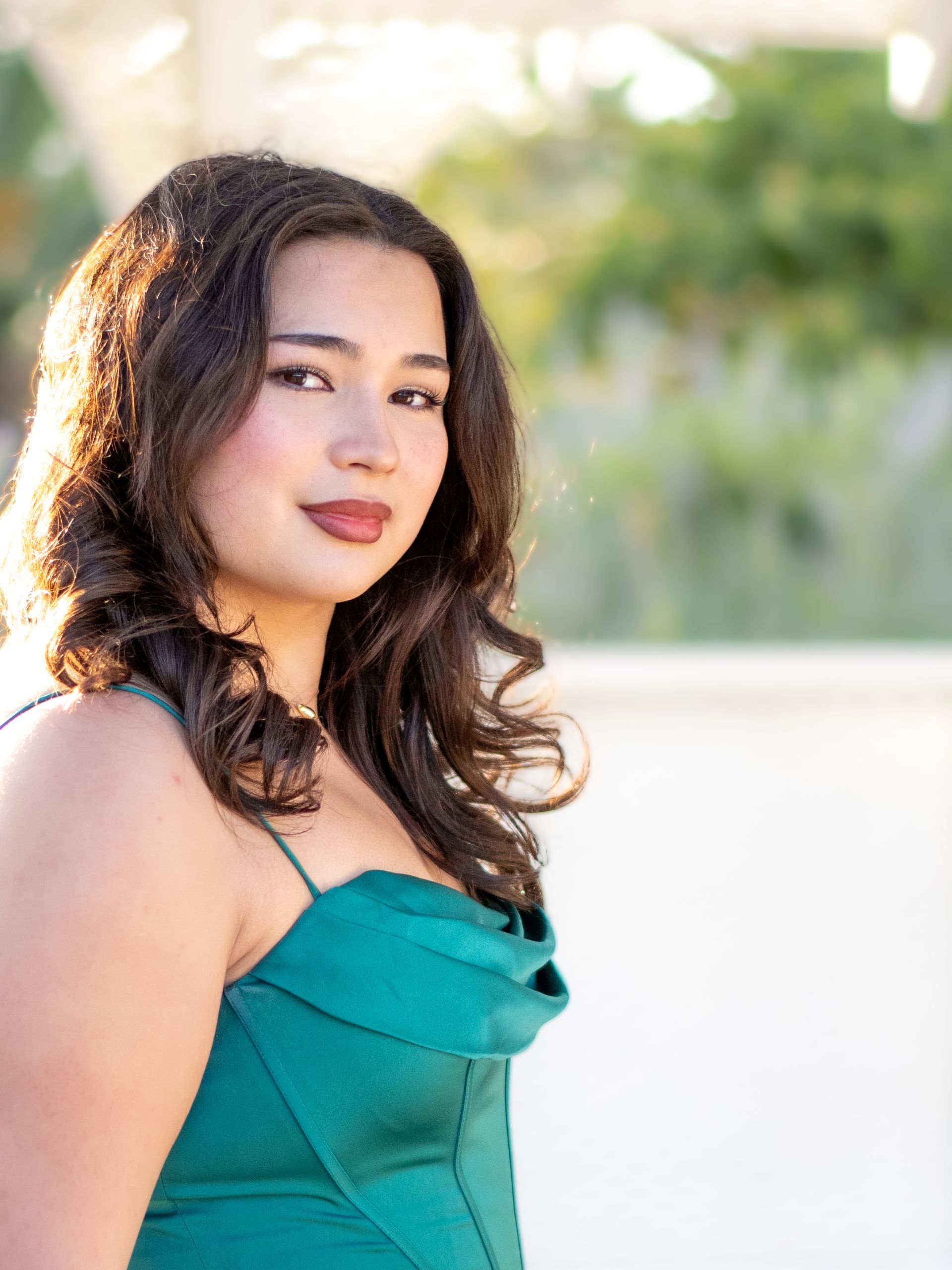 A woman in a green dress is standing in front of a gazebo in Averill Park. San Pedro, CA