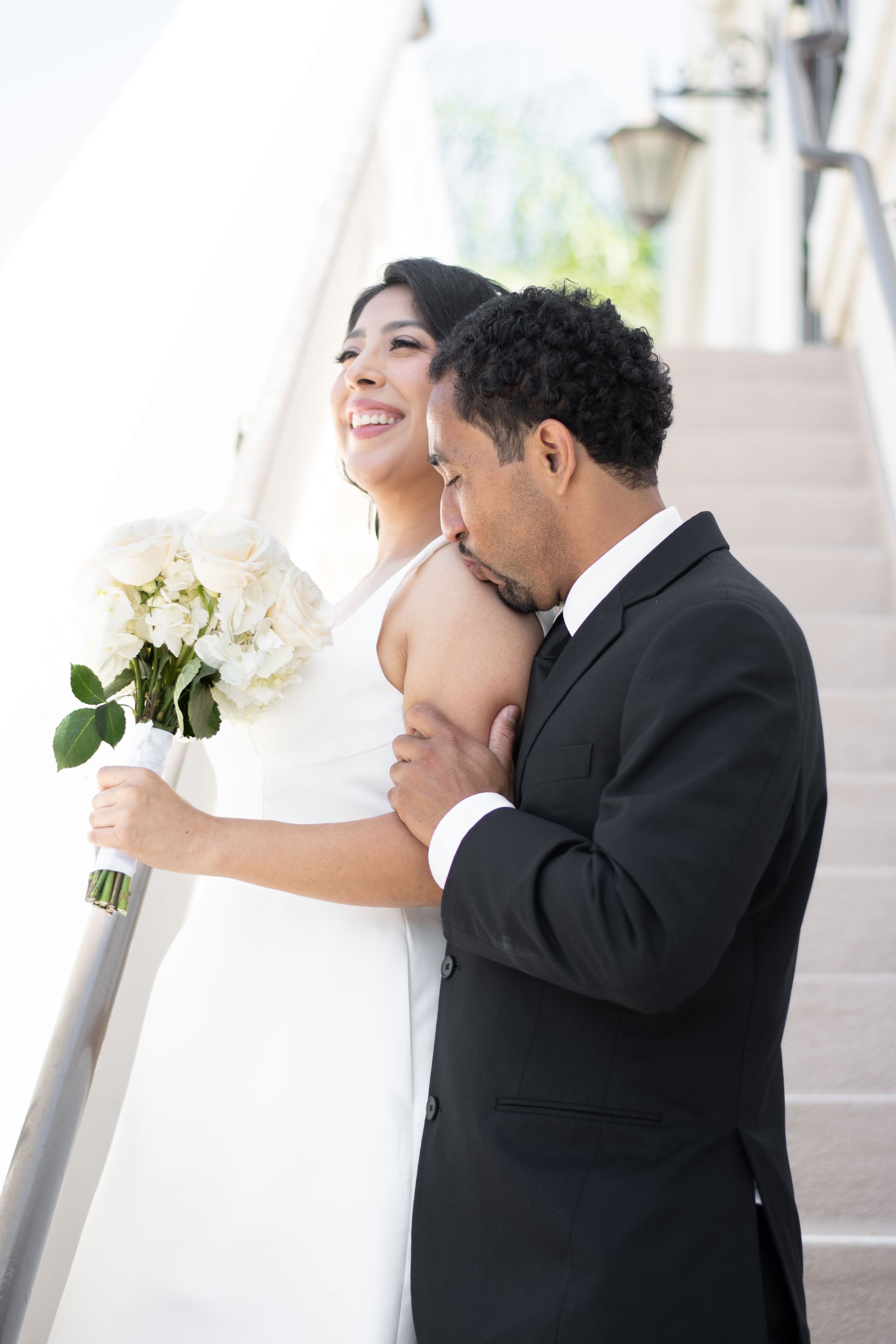 A bride and groom are posing for a picture on a set of stairs in Laguna Hills