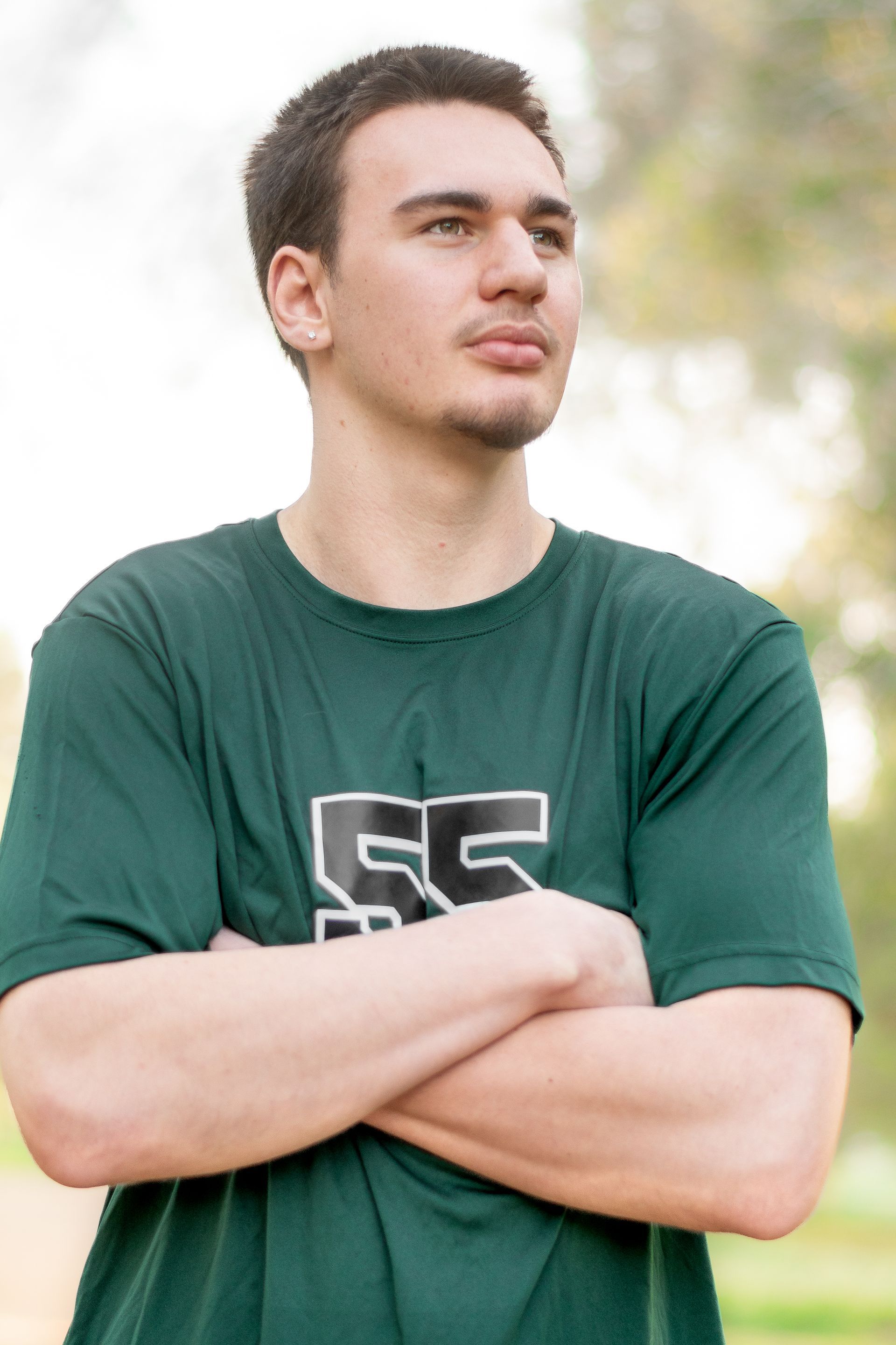 A person with dark hair wears a green t-shirt with 