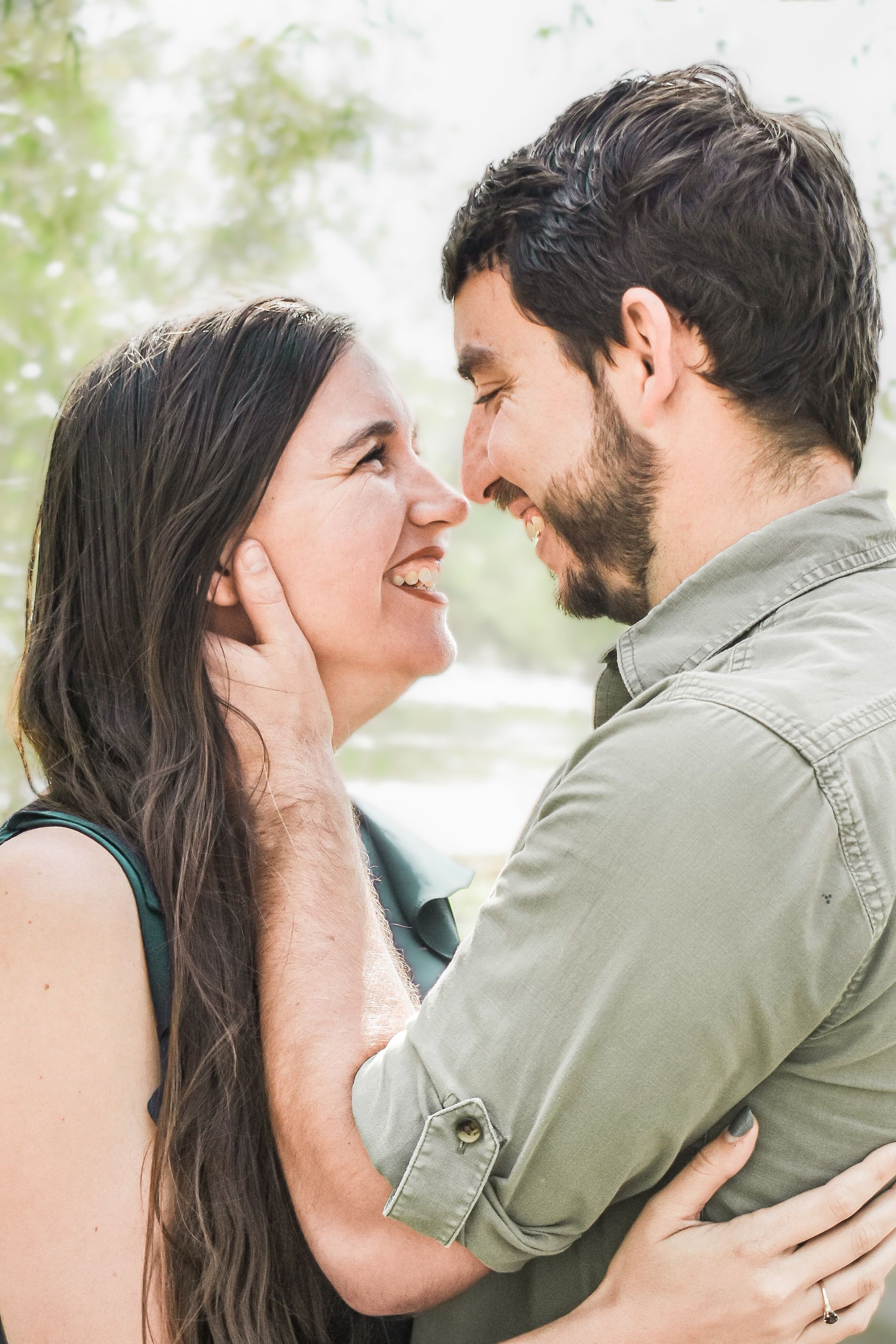 A man and a woman are sitting next to each other on a rocky beach.