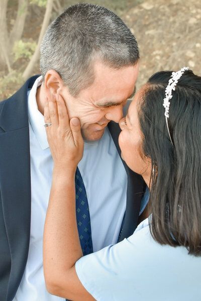 A woman is kissing a man on the forehead