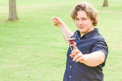A young man is holding a yo-yo in his hand in Banning park
