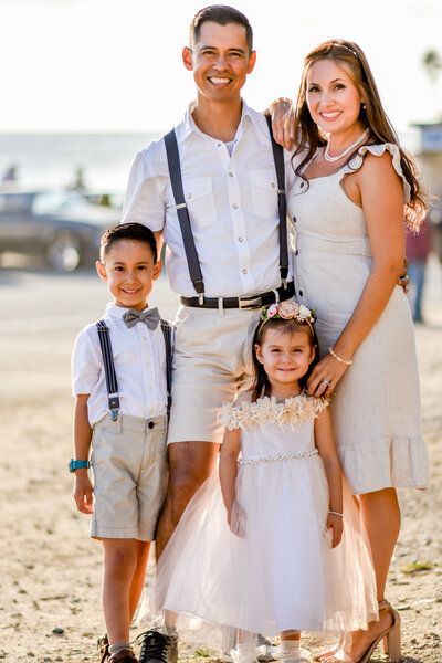 A family is posing for a picture on the beach.