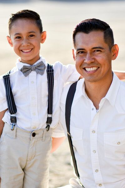 A man and a boy are posing for a picture on the beach... Like father like son Family. 