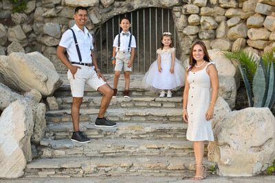 A family is posing for a picture on a set of stairs.