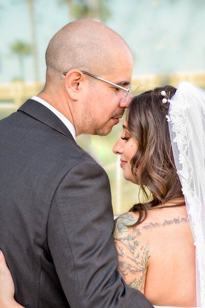 A bride and groom are looking into each other 's eyes. Wedding photo.