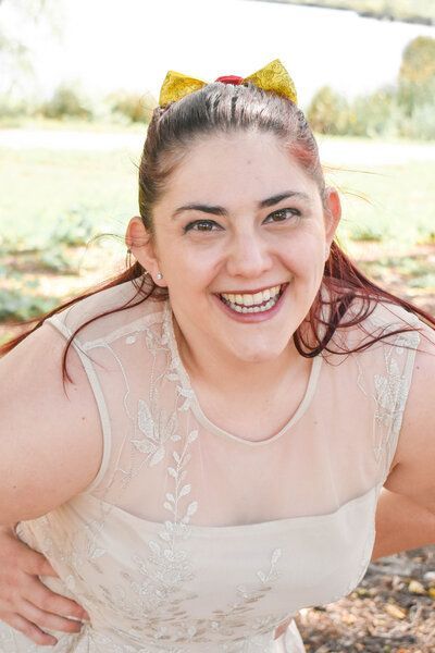 The woman is wearing a white dress and a yellow bow in her hair.