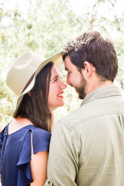 A man and a woman are looking at each other . the woman is wearing a hat.