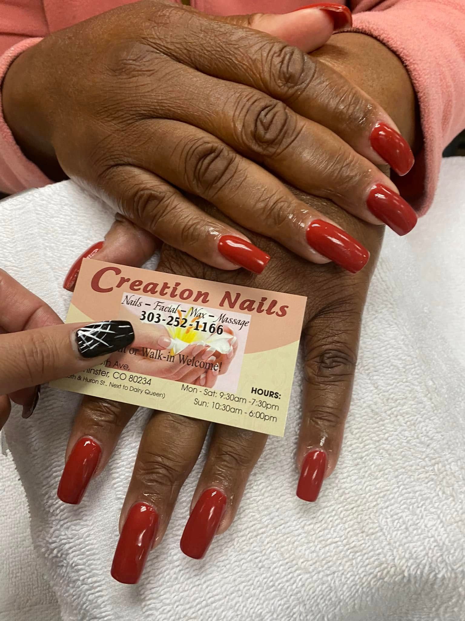 Hands with long, glossy red nails, holding a business card for 