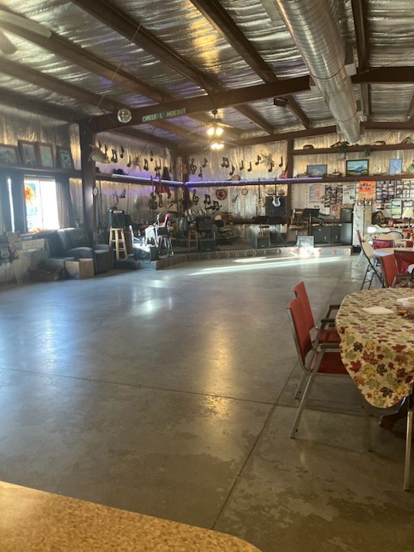 A large room with a dance floor and tables and chairs.