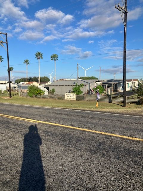 A shadow of a person is cast on the side of a road