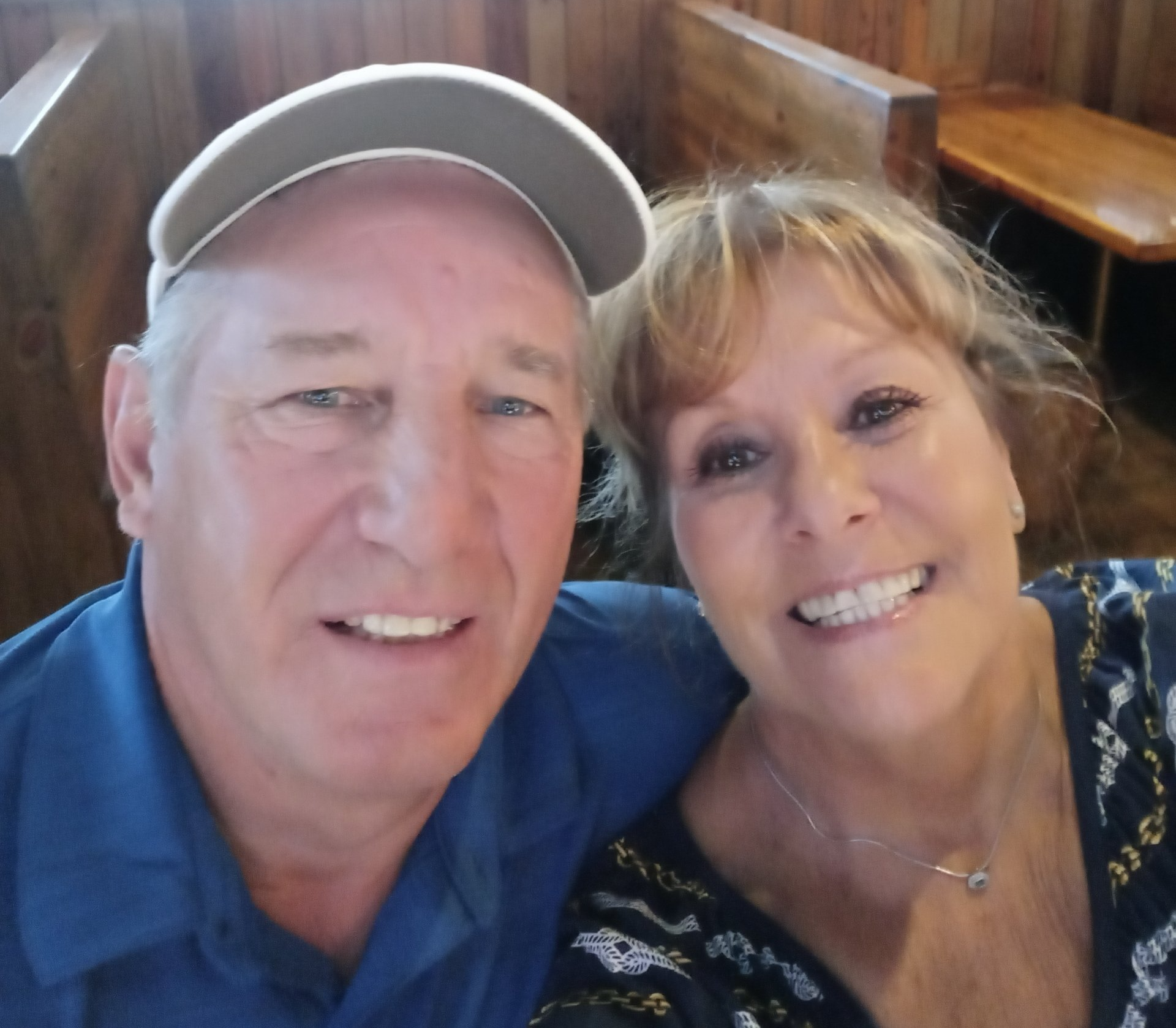 A man and a woman are posing for a picture and smiling