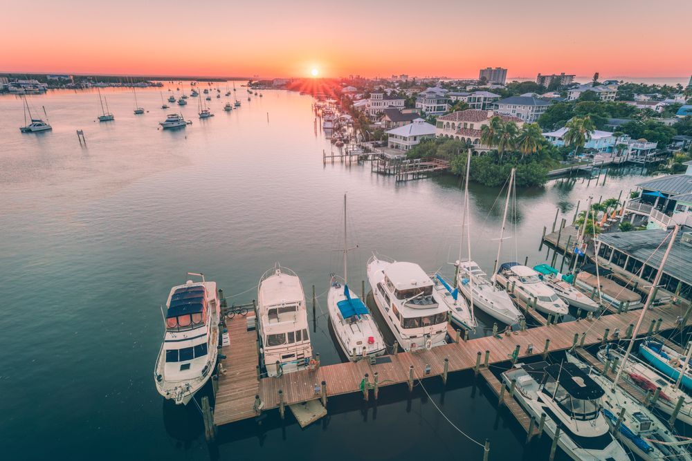 An aerial view of a marina with boats docked at sunset.