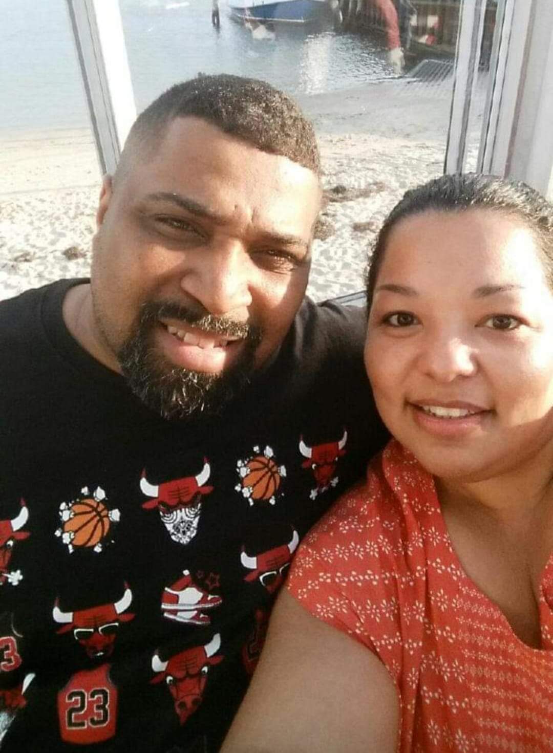 A man wearing a chicago bulls shirt poses with a woman