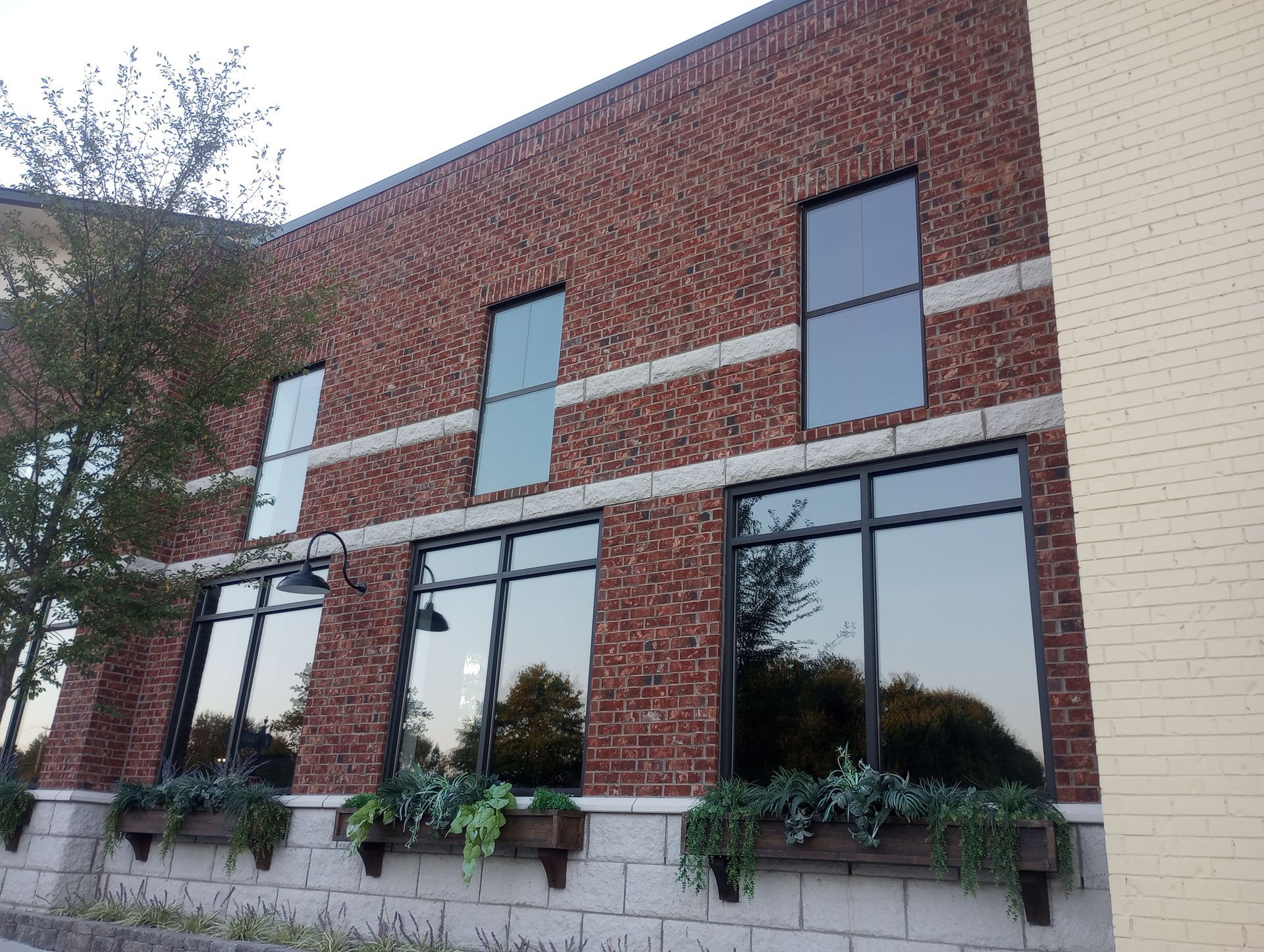 A brick building with a lot of windows and planters on the side
