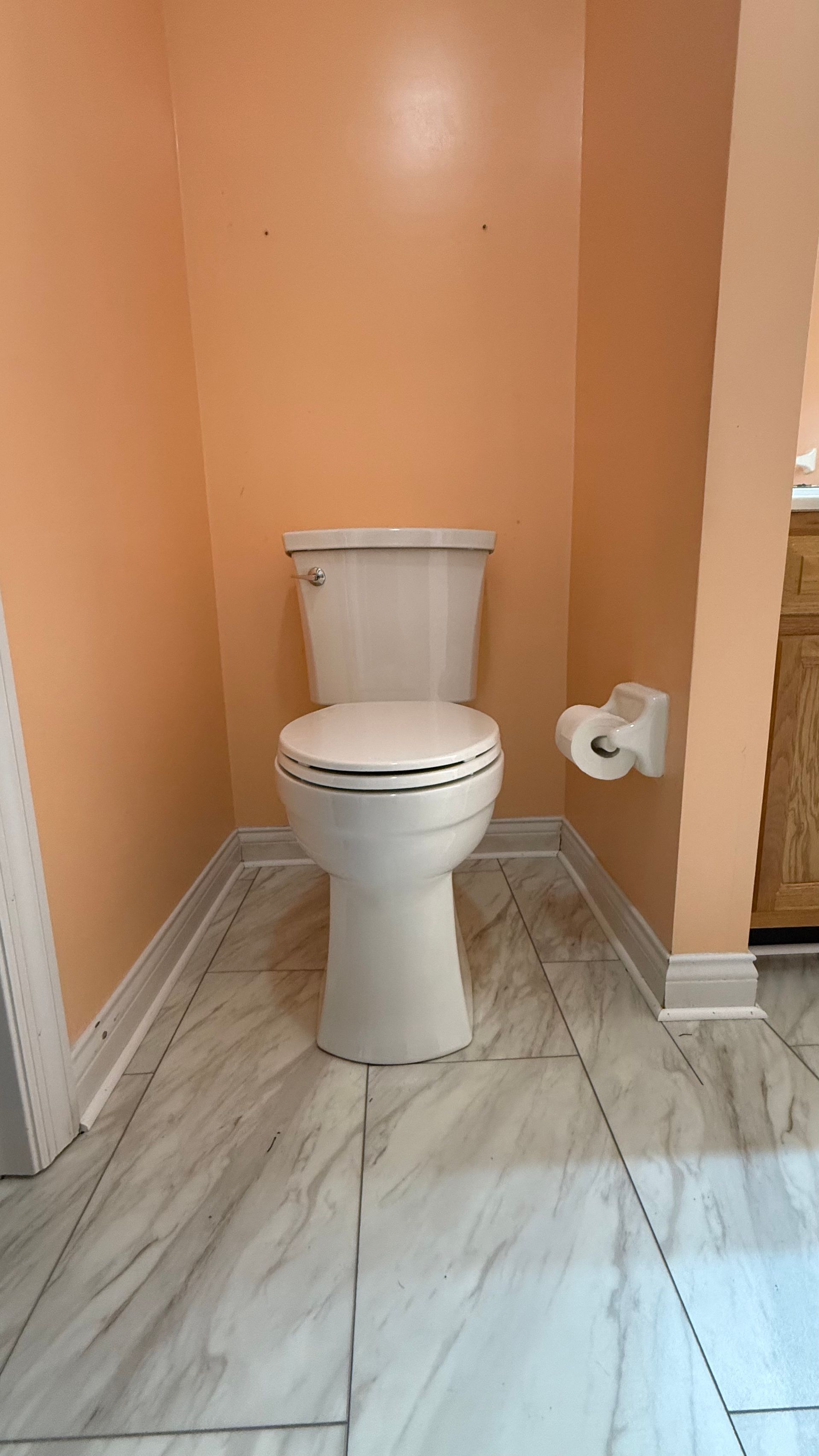 A toilet is sitting in a bathroom next to a wall.
