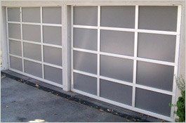 Two white garage doors with multiple square, frosted glass panes.